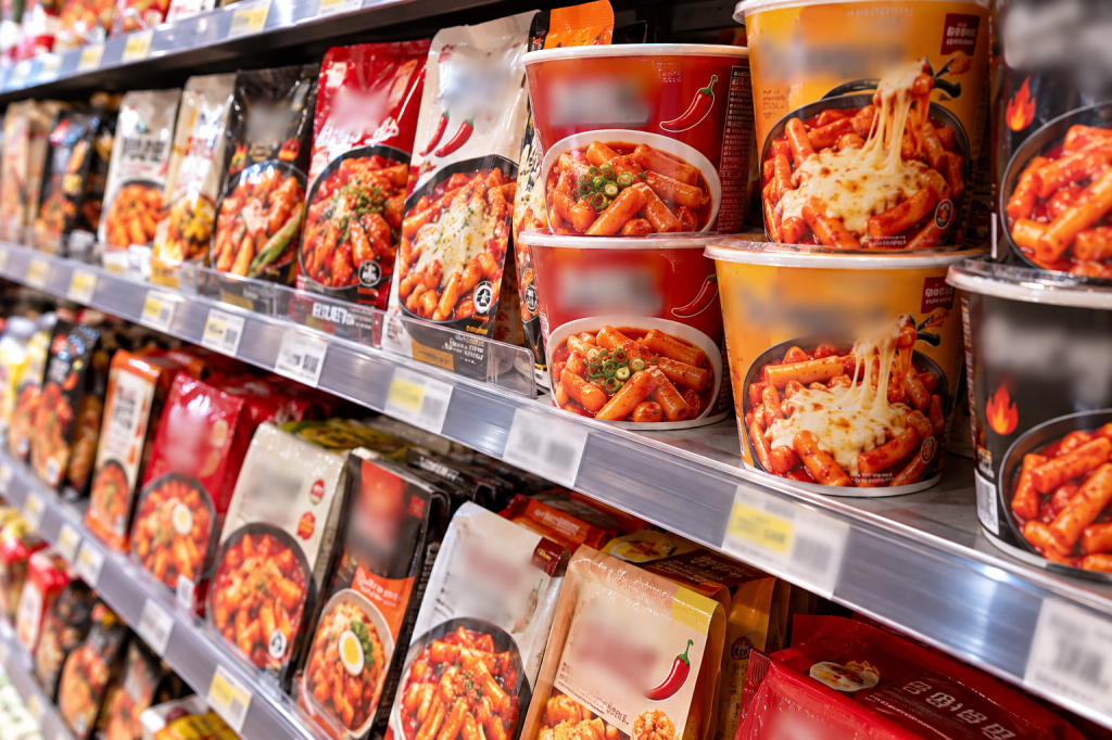 Instant tteokbokki cups and meal kits on a Korean grocery store shelf